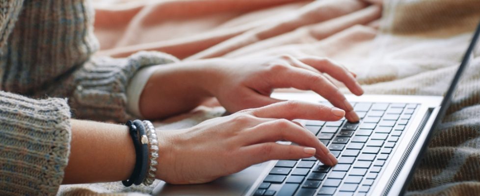 Unrecognizable woman type on laptop, close up view. Work at home, experienced freelance programming, writing code, remote job concept.