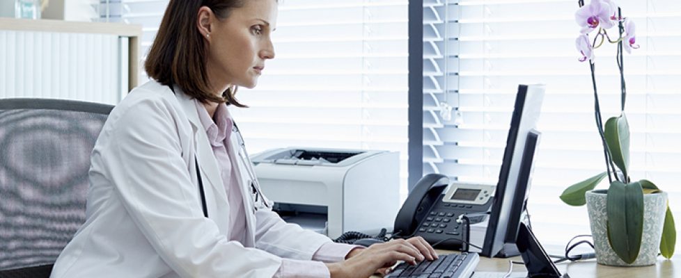 Female doctor working on computer at desk Female doctor working on computer at desk